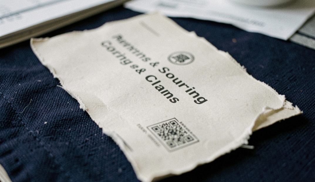 A quiet macro scene of sourcing & claims material with indigo texture and an unbleached edge